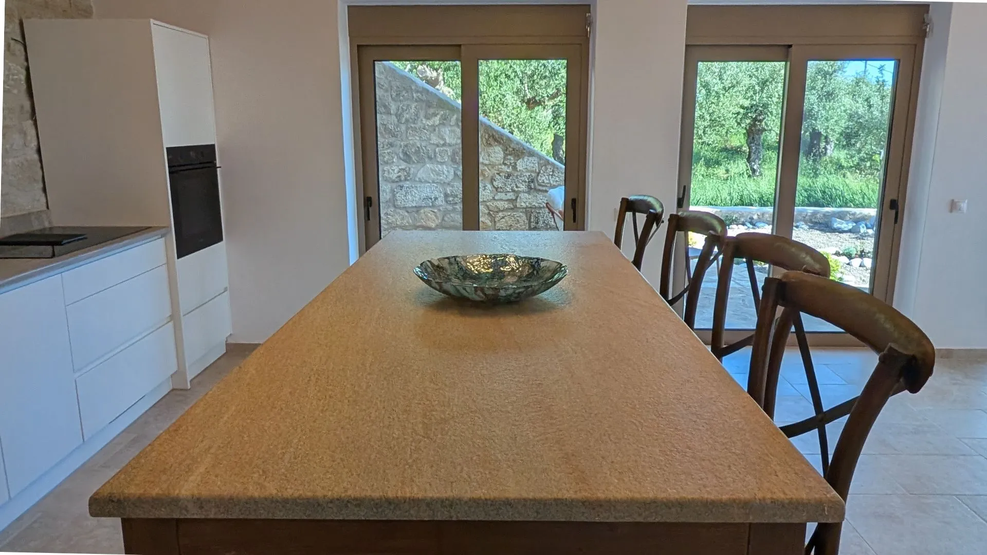 Kitchen at Achilles Cottage with a stone island and bar seating